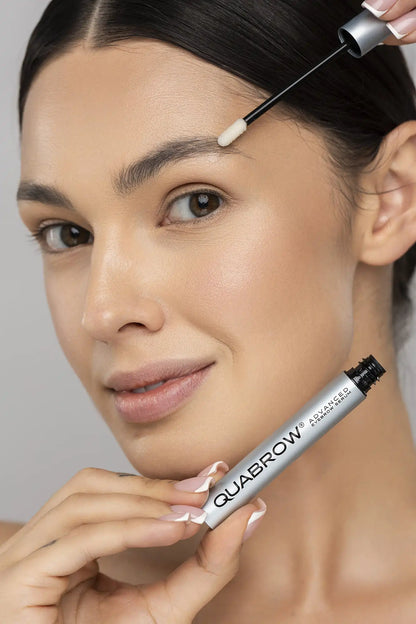 Brunette woman applying QUABROW Advanced Eyebrow Serum to the brow area with close-up on the applicator tip