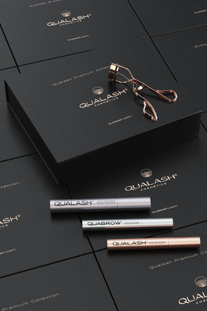 Flatlay of Qualash Premium Collection with curler and serums displayed outside the box